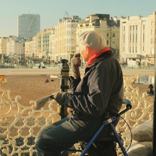a man sitting on top of a bench next to a fence