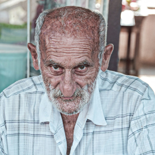an old man with a white beard is looking at the camera