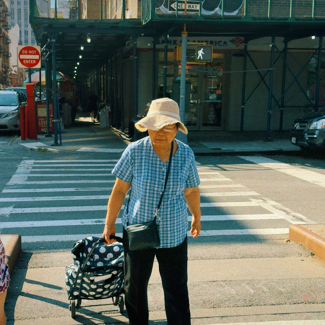 A man is crossing the street with a stroller