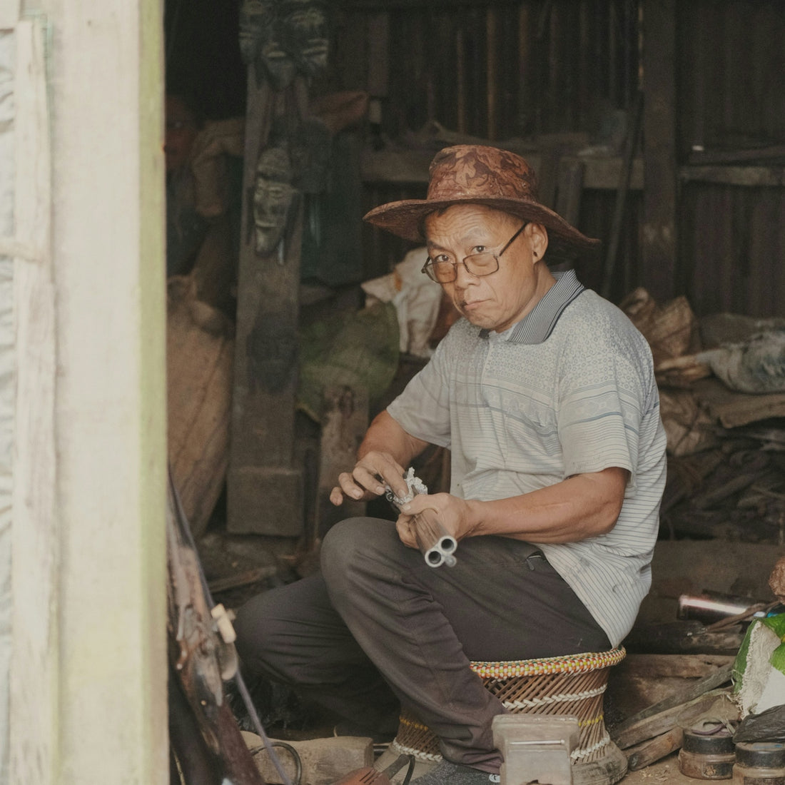 Man in hat cleaning a double-barreled shotgun.