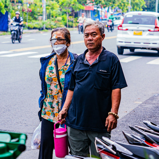 Elderly couple holding hands on city street