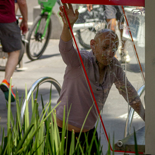 Bald man reaching for red cord near bicycles